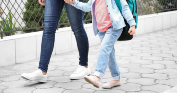 Parent hold hand of a child with backpack